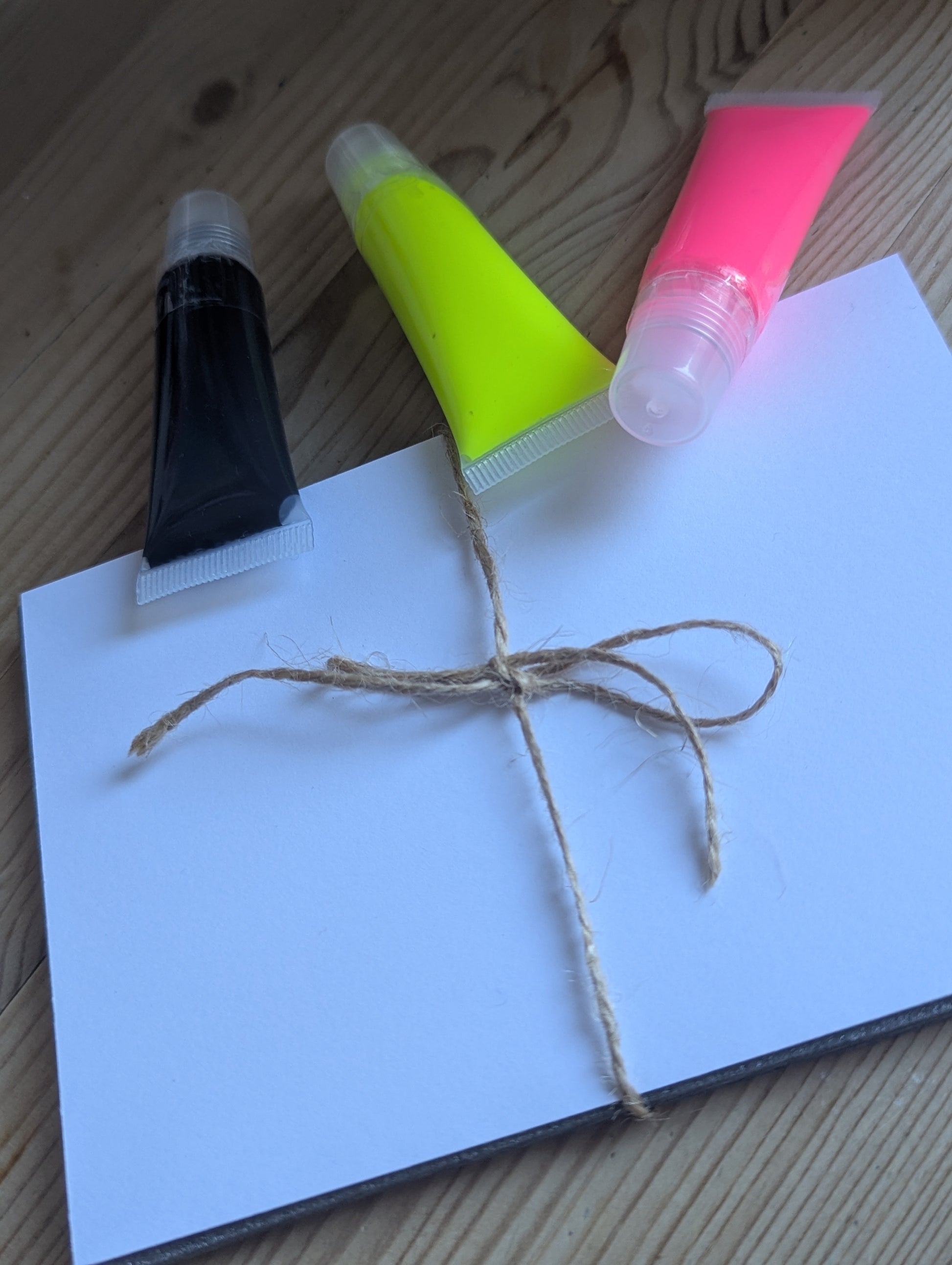 Three tubes with neon pink, neon yellow and black next to a pack of Fotocard 